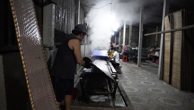 Công nhân dỡ các phên bánh ra khỏi băng chuyền. Ảnh: Hoàng Nam